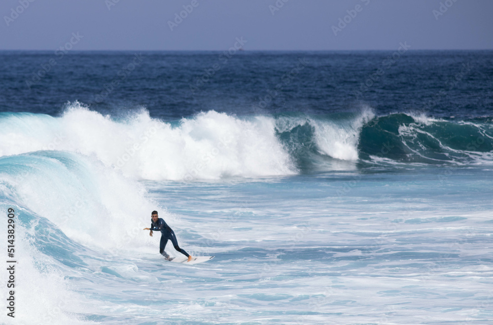 PUERTO DE SANTIAGO, TENERIFE - JUNE 2022: surfer riding the waves in Tenerife PUERTO DE SANTIAGO, TENERIFE - JUNE 2022: surfer riding the waves in Tenerife