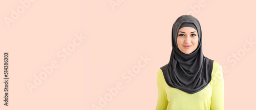 Beautiful young Muslim woman on color background with space for text © Pixel-Shot