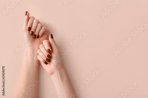 Female hands with beautiful brown manicure on light background