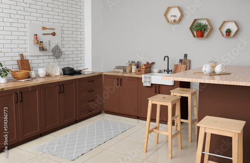 Interior of light kitchen with brown furniture