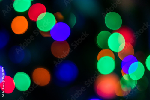 Multi-colored lights with red, green, purple, orange colored on the dark background. The whole shot is strong defocused to use bokeh simulation.