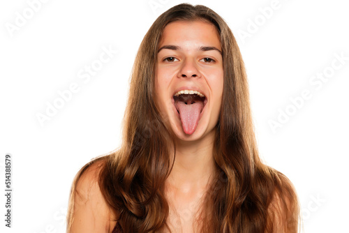 Photo Young woman with her tongue sticking out, isolated on white.