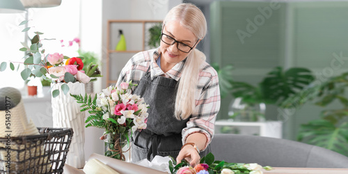 Mature female florist makin...
