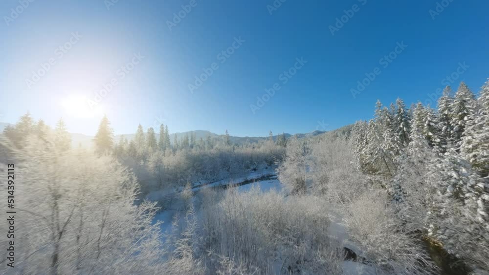 Flight along a mountain river surrounded by a snow-covered forest. Tatra Mountains, Zakopane, Poland. Filmed on FPV Drone Flight along a mountain river surrounded by a snow-covered forest. Tatra Mountains, Zakopane, Poland. Filmed on FPV Drone