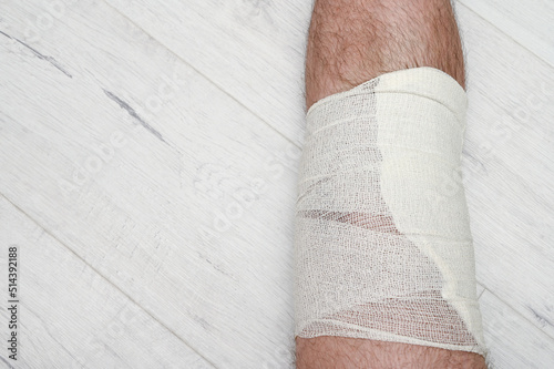 Print op canvas Bandaged leg after knee injury. Elastic self-adhesive bandage.