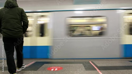 A man is waiting for a train in the subway.