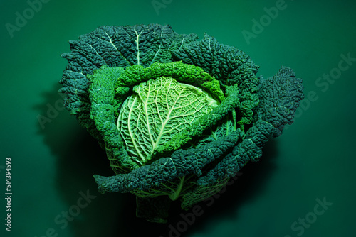Fresh beautiful savoy cabbage head over green background