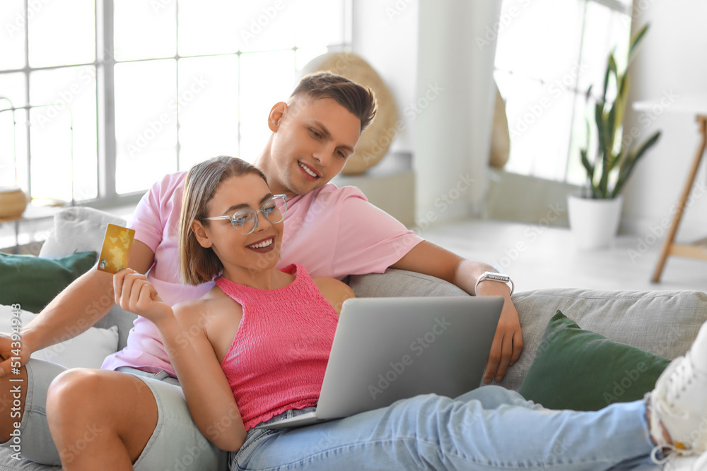 Young couple with laptop and credit card at home. Online shopping Young couple with laptop and credit card at home. Online shopping