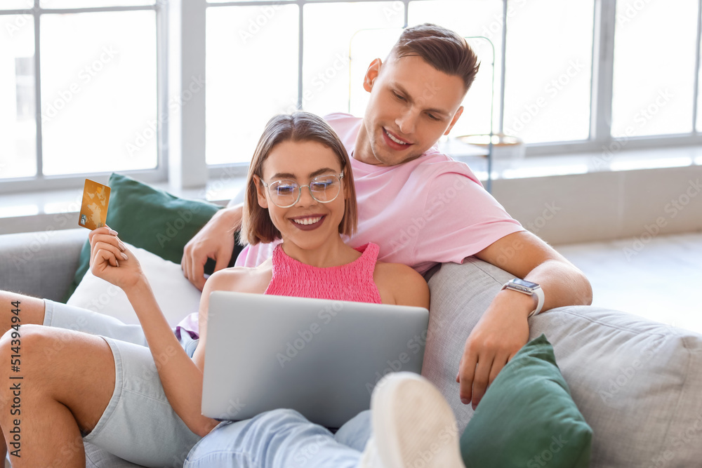 Young couple with laptop and credit card at home. Online shopping Young couple with laptop and credit card at home. Online shopping