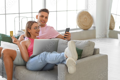 Young couple with laptop, m...