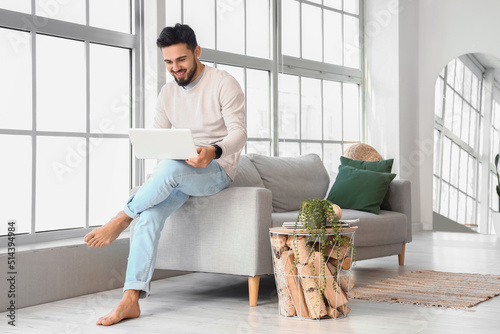 Handsome barefoot man using...