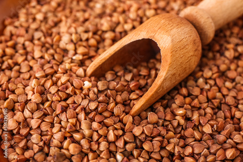 Wooden scoop with buckwheat grains, closeup