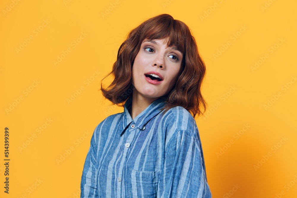 horizontal photo on a yellow background of a cute, happy woman in a blue shirt horizontal photo on a yellow background of a cute, happy woman in a blue shirt