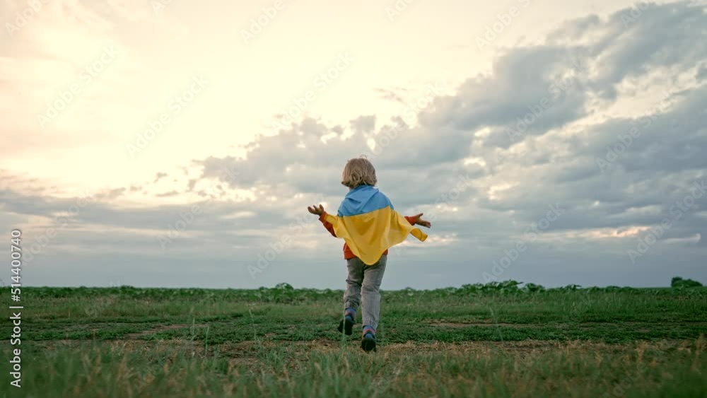 Cute little boy - Ukrainian patriot kid running with national flag on open area field. Ukraine, peace, independence, freedom, victory in war. Cute little boy - Ukrainian patriot kid running with national flag on open area field. Ukraine, peace, independence, freedom, victory in war.