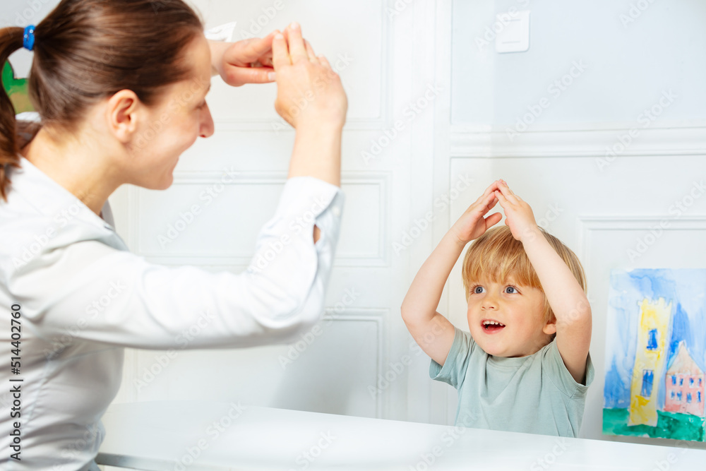 Handsome boy in development finger game class with therapist Handsome boy in development finger game class with therapist