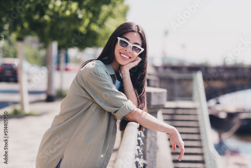 Photo of pretty adorable girlfriend wear green outfit dark eyewear walking sunny weather outdoors city street © deagreez