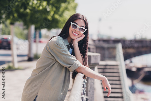 Photo of pretty adorable girlfriend wear green outfit dark eyewear walking sunny weather outdoors city street