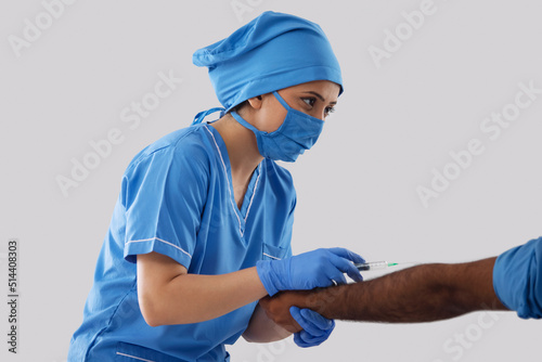 Female nurse injecting Covid-19 Vaccine to a patient