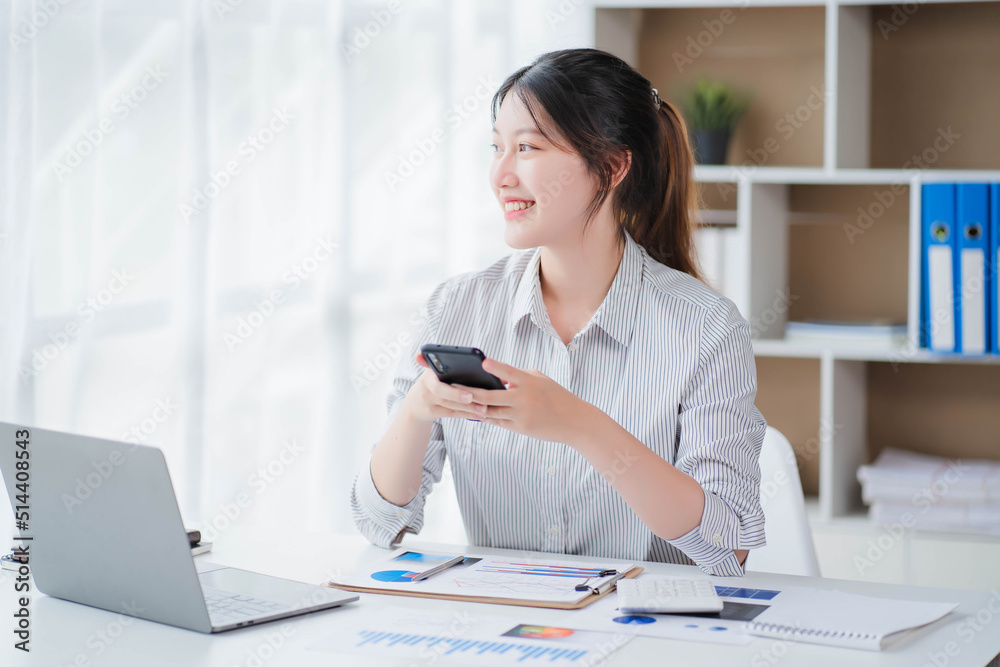 Young asian businesswoman beautiful charming smiling and talking on the mobile phone in the office Young asian businesswoman beautiful charming smiling and talking on the mobile phone in the office