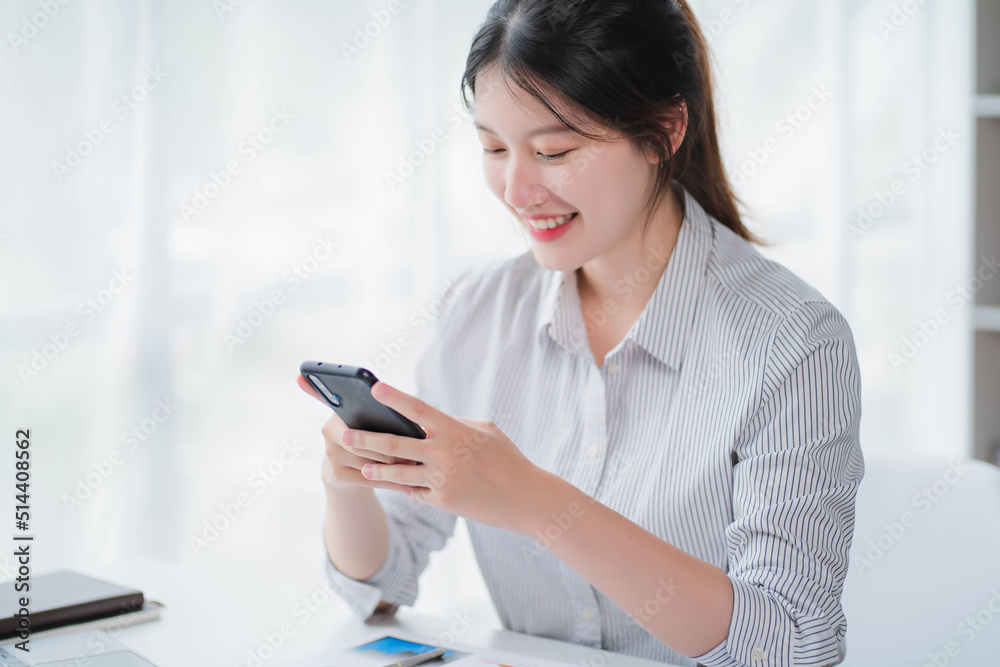 Young asian businesswoman beautiful charming smiling and talking on the mobile phone in the office Young asian businesswoman beautiful charming smiling and talking on the mobile phone in the office