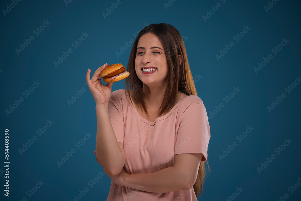 Portrait of a cheerful woman holding hamburger Portrait of a cheerful woman holding hamburger