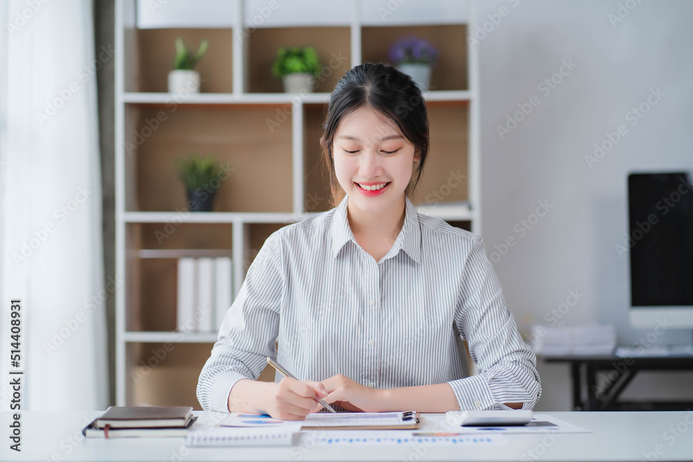 Young asian businesswoman beautiful charming smiling and talking on the mobile phone in the office Young asian businesswoman beautiful charming smiling and talking on the mobile phone in the office
