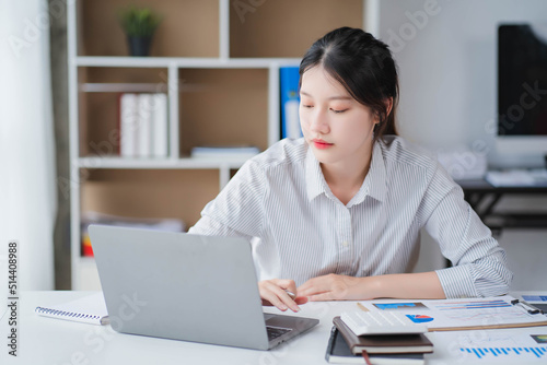 Young asian businesswoman beautiful charming smiling and talking on the mobile phone in the office