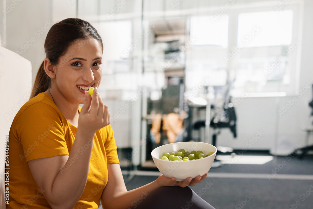 Portrait of a happy young woman eating grapes Portrait of a happy young woman eating grapes
