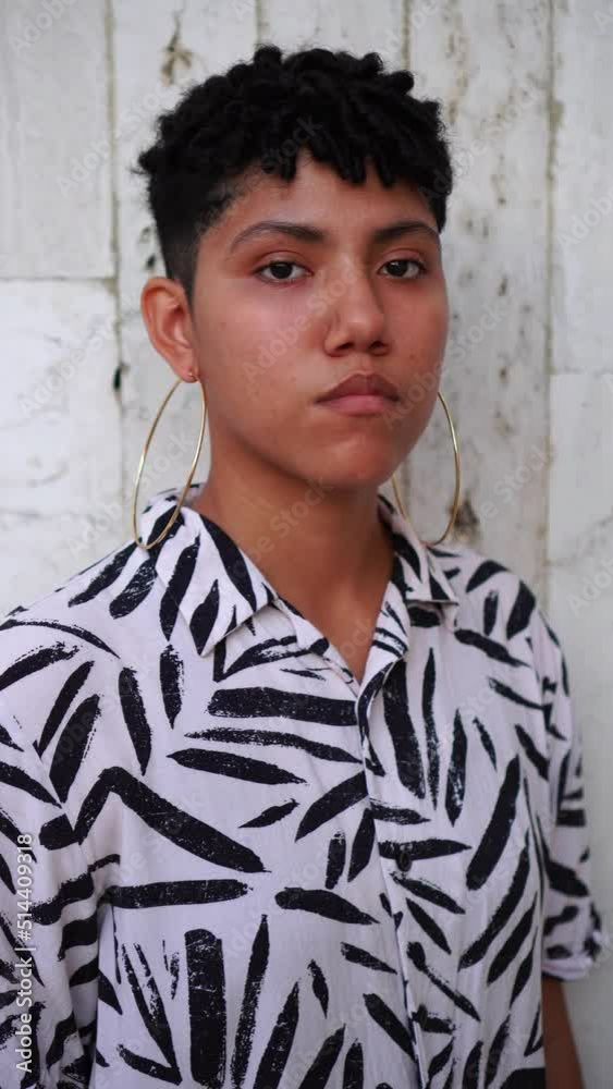 Serious non-binary person looking at the camera outdoors Serious non-binary person looking at the camera outdoors