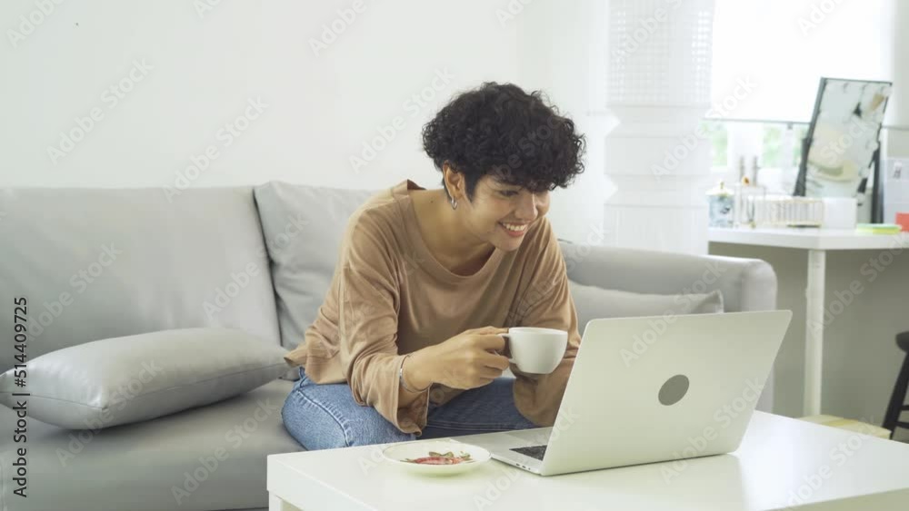 Portrait of business Asian woman, person working online at home or house, drinking a cup of coffee, using a computer laptop notebook, technology device. People lifestyle.