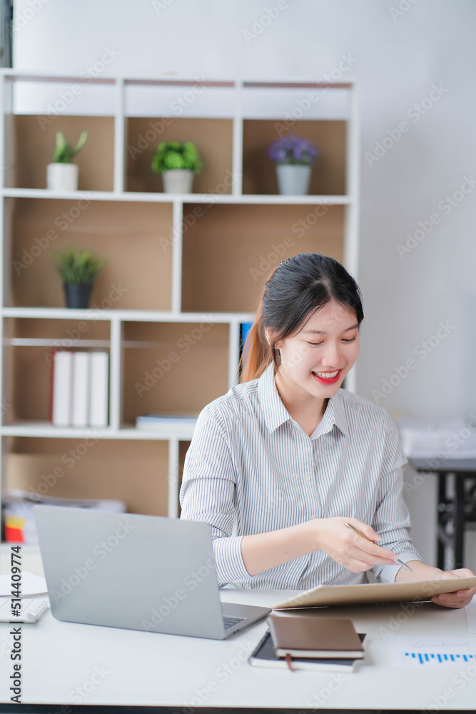 Young asian businesswoman beautiful charming smiling and talking on the mobile phone in the office