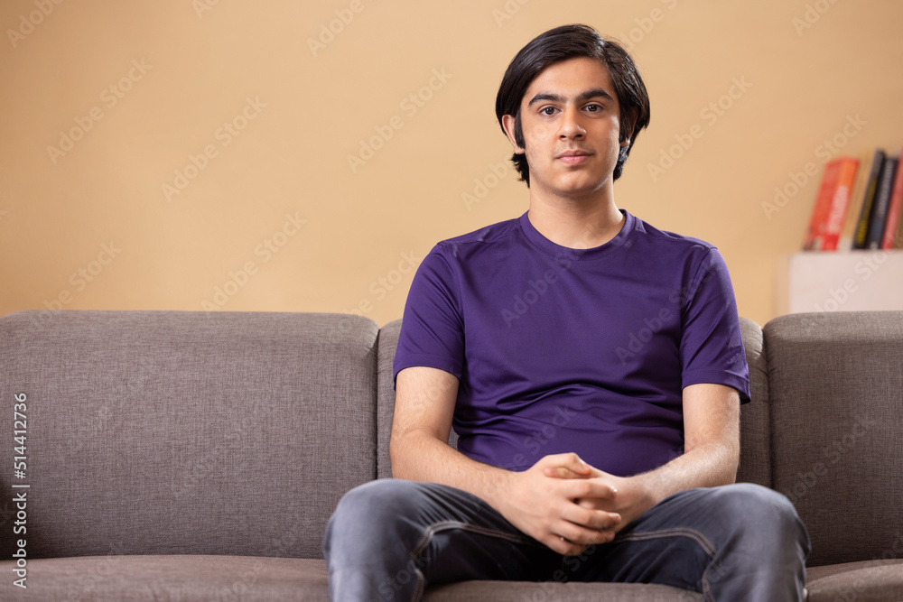 Portrait of teenage boy sitting on sofa in living room Portrait of teenage boy sitting on sofa in living room