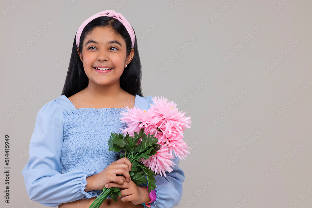 Portrait of happy girl holding a bouquet of flowers against plain background Portrait of happy girl holding a bouquet of flowers against plain background