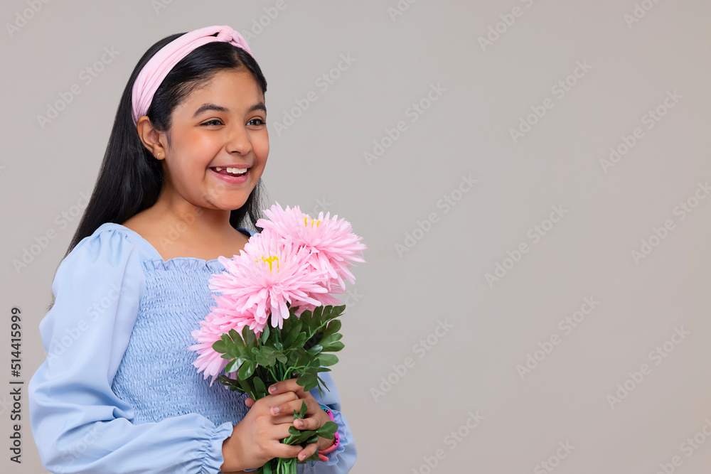 Portrait of happy girl holding a bouquet of flowers against plain background Portrait of happy girl holding a bouquet of flowers against plain background