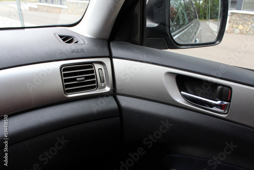 Car air vents close-up grille. Air ventilation grille with power regulator in light interior. © Best Auto Photo