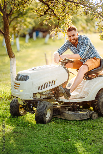 Professional gardner using lawn mower and premium tools for grass cutting