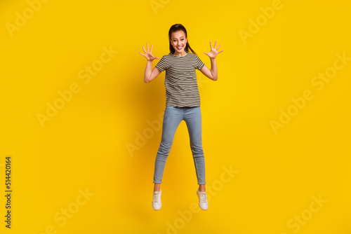 Full length body size photo of jumping high female student gesturing overjoyed isolated on bright vivid color background