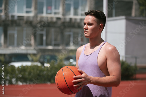 young guy plays basketball on the basketball court. throws the ball into the ring. doing sports. healthy body and healthy lifestyle © Дмитрий Дементьев