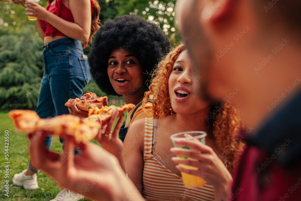 Friends having pizza in park