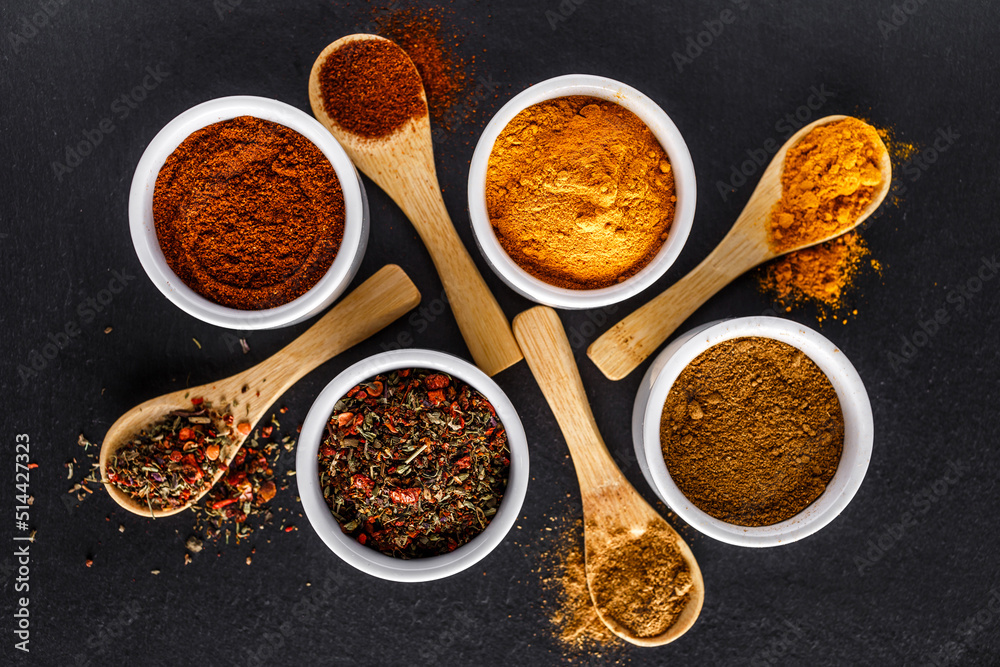 Various spices a vintage spoons on stone table. Colorful Herbal and Spices Oriental marketplace.Top view . Cafe concept. Delicious food delivery.