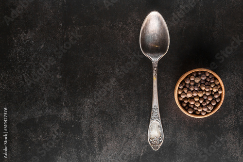 Peppercorn background. Dry black pepper seeds. Top view.On a black background. free space for your text. © bukhta79