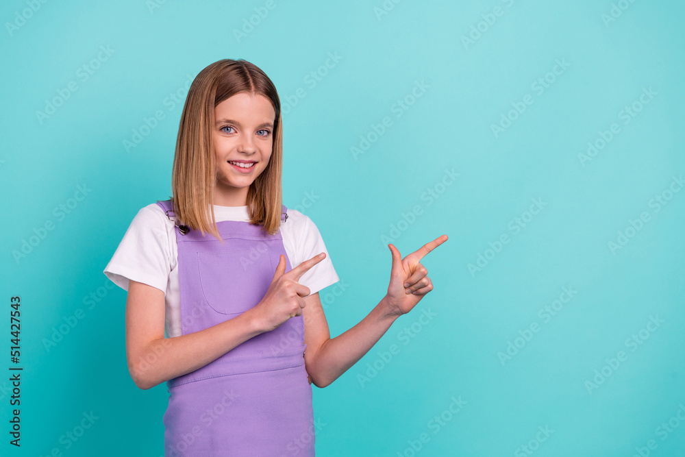Photo of sweet lovely girl toothy smile direct fingers empty space advert isolated on teal color background Photo of sweet lovely girl toothy smile direct fingers empty space advert isolated on teal color background