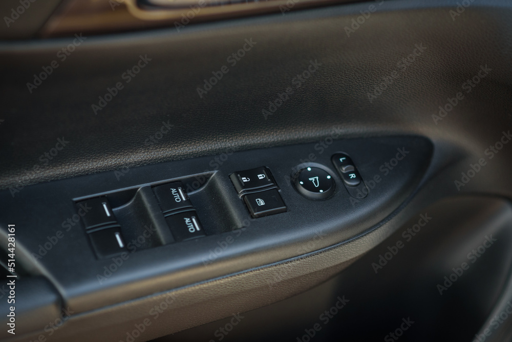 Car door control left panel. Window lifters control. Blocking opening and closing of windows and doors. Armrest with setting outside mirror adjustment button. Side and rear window switch. Door trim.