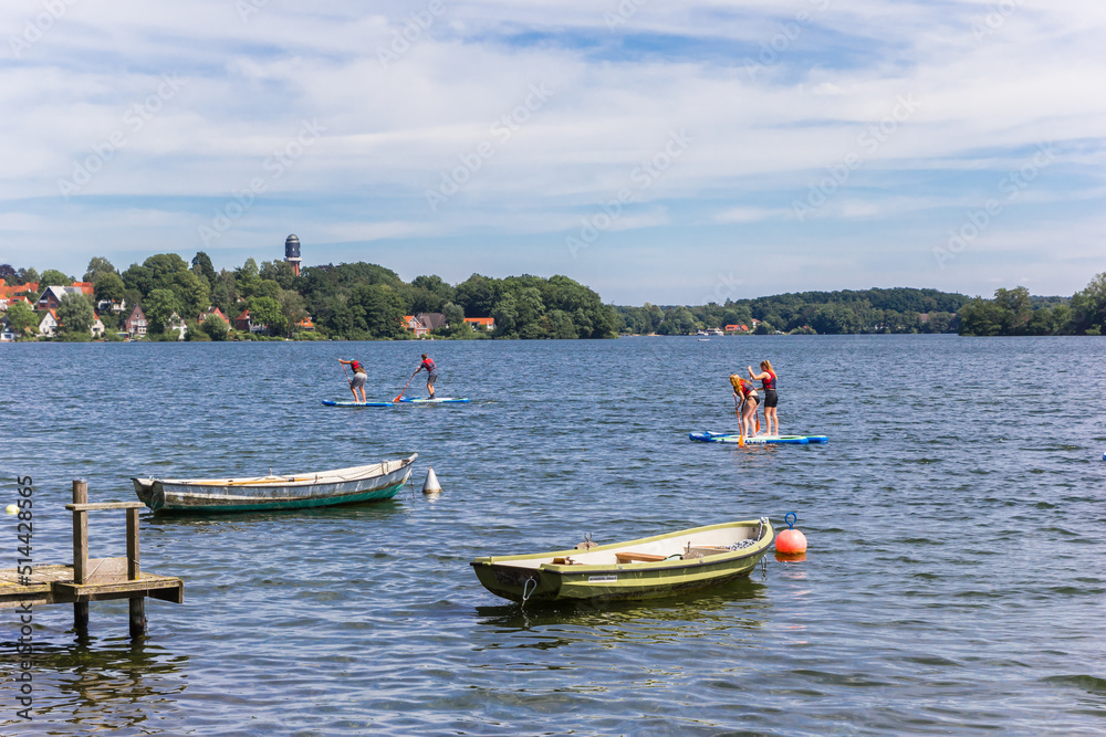 People doing standup paddleboarding in the lake of Plon, Germany