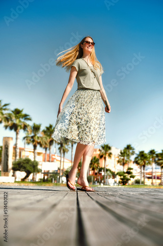 Woman in a green dress is dancing in the street