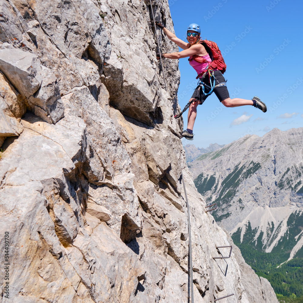 Fototapeta premium Active woman on via ferrata Nordkette Innsbruck, Austria. Rock details, adventure, activity, tourism, klettersteig.