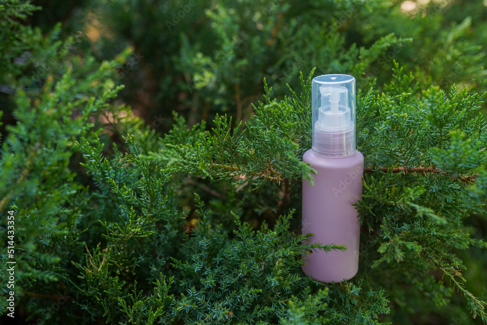 Purple cosmetic bottle with serum, essential oil or other skin care product in forest outdoors. Natural Organic Spa Cosmetic Beauty concept. mockup Purple cosmetic bottle with serum, essential oil or other skin care product in forest outdoors. Natural Organic Spa Cosmetic Beauty concept. mockup