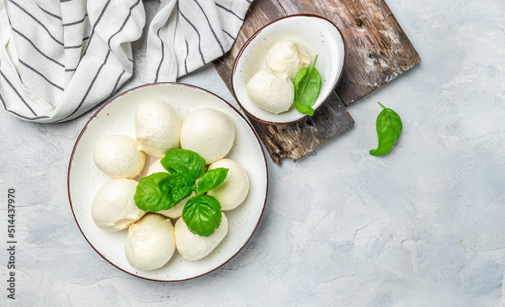 Cheese collection, white balls of soft Italian cheese mozzarella, served with fresh basil leaves on a light background, place for text, top view Cheese collection, white balls of soft Italian cheese mozzarella, served with fresh basil leaves on a light background, place for text, top view