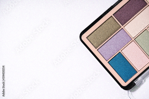 Canvas Print Glitter eyeshadows palette for festive makeup over white holographic background with copy space for text