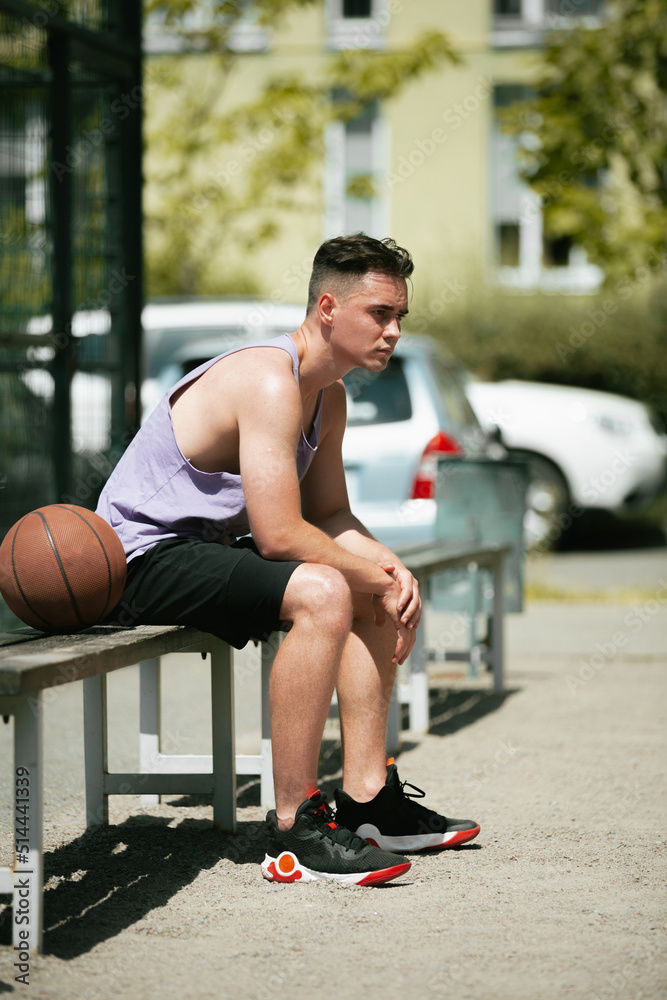 young guy plays basketball on the basketball court. throws the ball into the ring. doing sports. healthy body and healthy lifestyle young guy plays basketball on the basketball court. throws the ball into the ring. doing sports. healthy body and healthy lifestyle